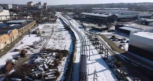 Passenger Train Rides By Rail in a Snowy Place From Aerial View