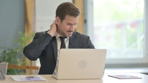 Man Working at Desk Experiencing Neck Pain