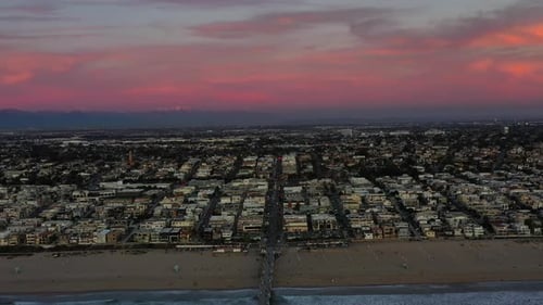 Aerial View Of Manhattan Beach City And Pier During Sunset With Pink Skies In California USA. - pull