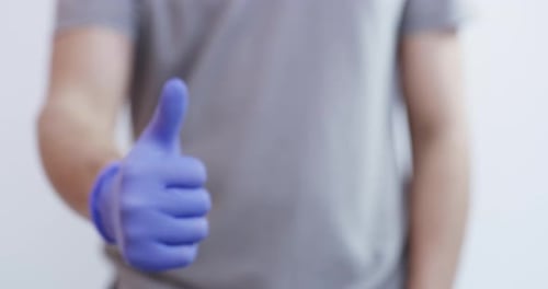 Blue Gloved Hand Gives Thumbs Up