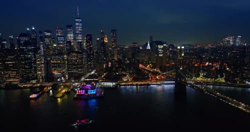 Skyscrapers of New York full of lights at night. View on the gorgeous buildings from the river side