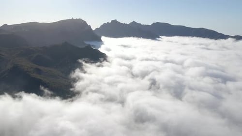 Flying above the clouds - amazing view of the clouds and the peak of the mountains on a sunny day. B