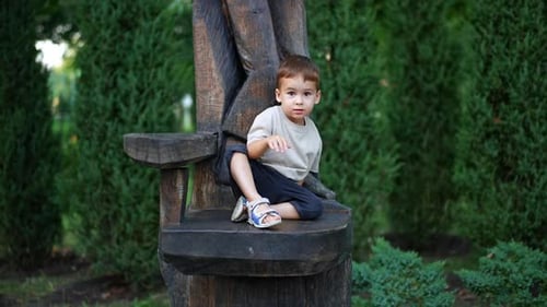 Adorable Child Sitting on a Wooden Throne Chair
