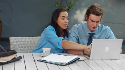 Man and Woman Work on Laptop Together