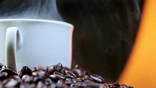 Una pila de granos de café y una taza de café caliente sobre un tocadiscos