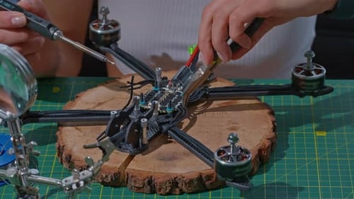 Weibliche Hände halten Drähte bei der Herstellung einer Drohne