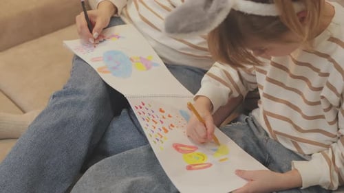 Woman and Child Drawing Together at Home