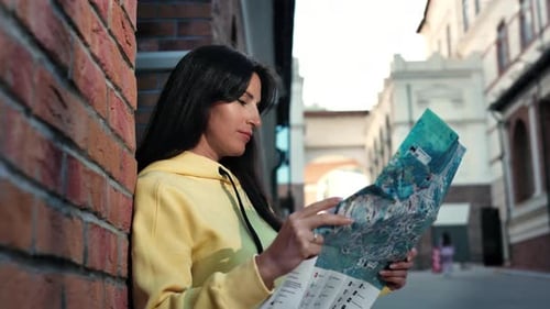 Woman Looking at a Map in the City