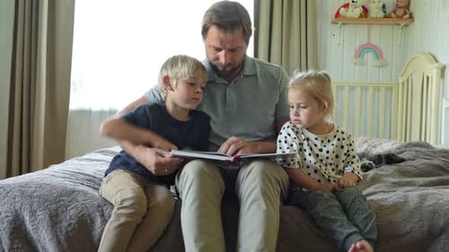 Loving Father Reading Book with Son and Daughter