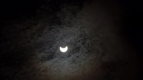 Partielle Sonnenfinsternis am 25. Oktober 2022. Sich schnell bewegende Wolken über der Sonnenfinsternis