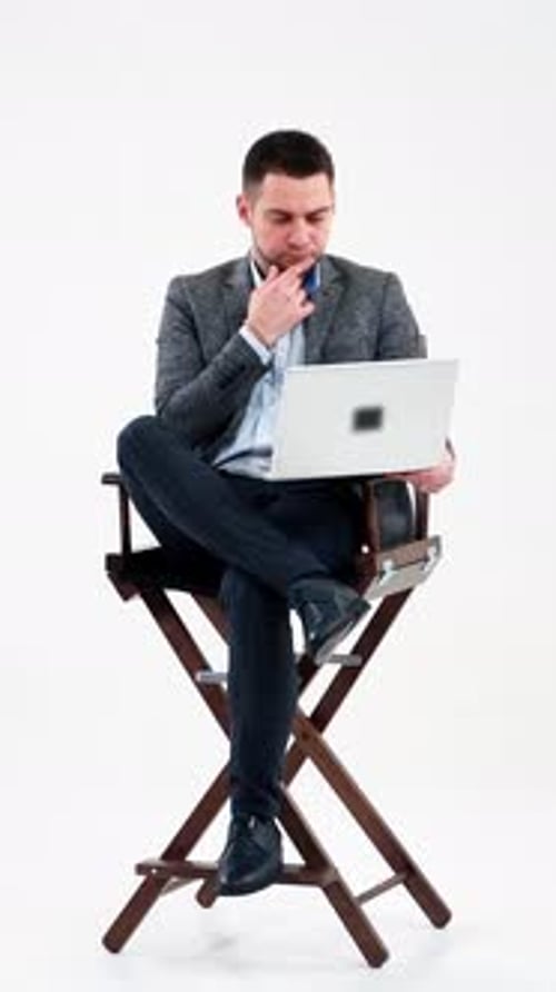 Thoughtful businessman with laptop isolated on white.