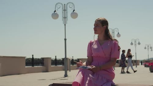 Woman Sits on Bench and Twirls Hair