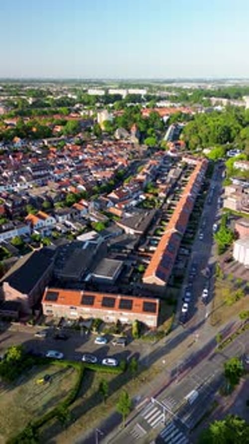 Aerial view of a dense suburban area with rows of red‑tiled houses, narrow streets, parked cars