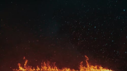 Snowflakes gently falling on a fiery hot fire flames background