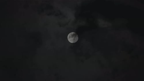 Full Moon Behind Dark Clouds in Night Sky