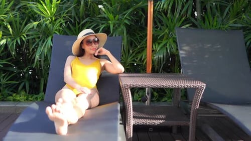 Une chaise longue est l'endroit idéal pour bronzer et regarder le monde passer dans la piscine de l'hôtel.