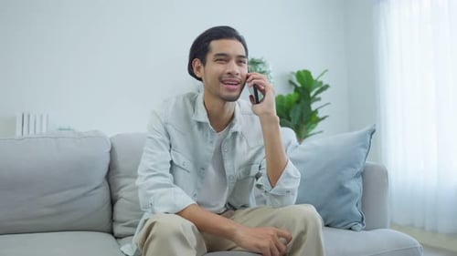 Man Talking on Phone Relaxing on Couch