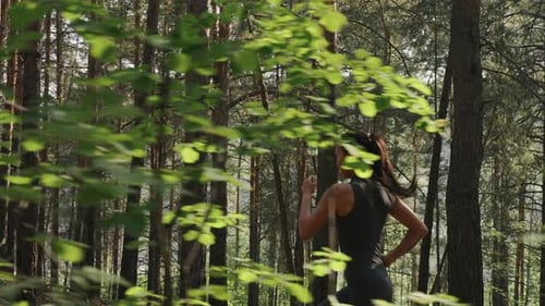 Young Female Athlete Jogging in Forest