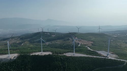 Aerial View Of Wind Energy Turbines Among Green Hills