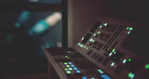 Control Panel with Illuminated Buttons in a Dark Room During Late Hours