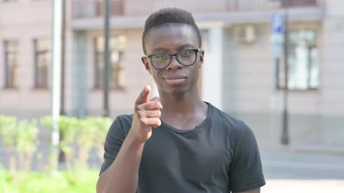 Young Adult Gesturing Come Here Outdoors