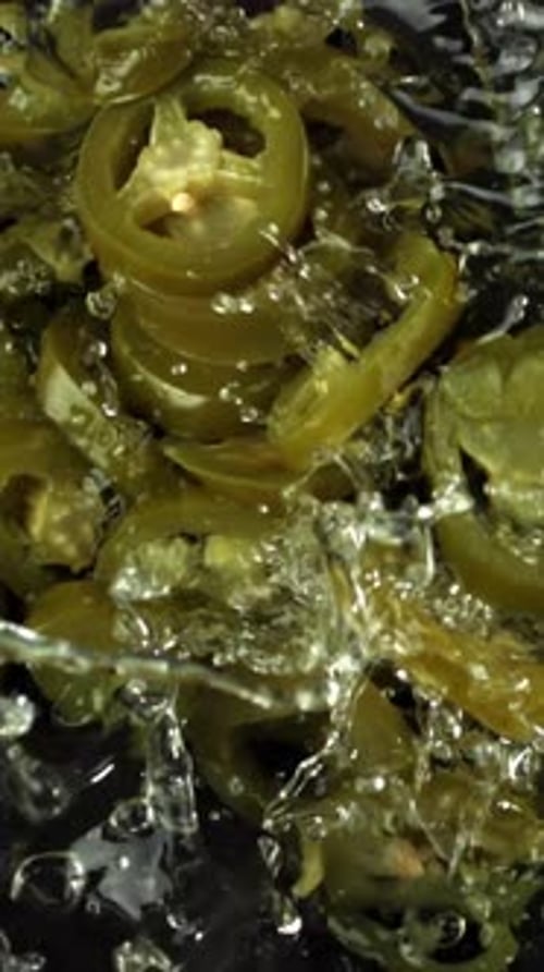 Les jalapenos marinés tombent à l'eau filmés par une caméra haut débit à 1000 images par seconde