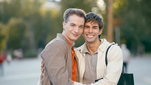 Affectionate gay couple embracing in a green outdoor setting