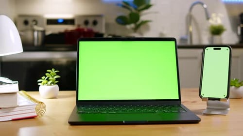 Nahaufnahme eines Laptops mit grünem Bildschirm auf dem Schreibtisch in der Küche bei Nacht Kreatives Setup