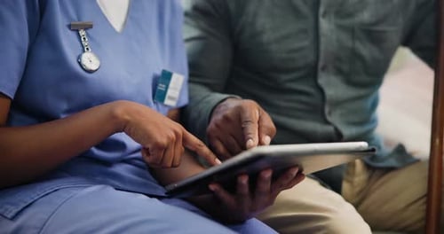 Healthcare Worker Using Tablet with Patient