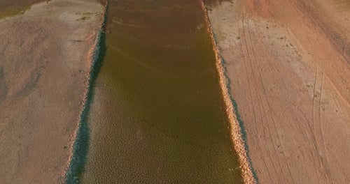 A Dried Up Water Source River Flowing Into a Lake