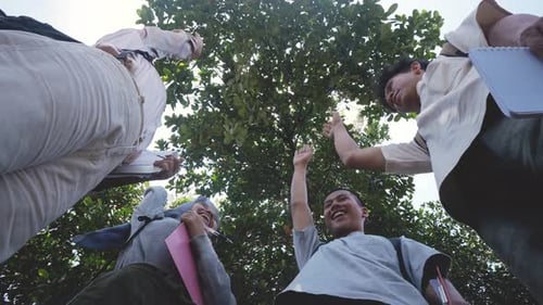 Four Young Adults Celebrate Graduation Outdoors