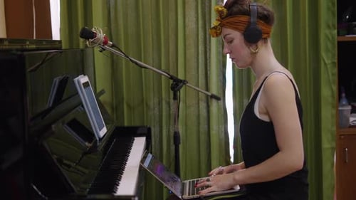 Woman Sings and Plays Piano with Laptop