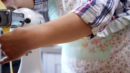 Woman Making Pasta with Machine in Home Kitchen