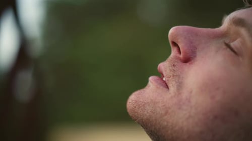Peaceful Man Enjoying Outdoor Serenity Calm Individual Exhaling Cigarette in Natural Setting