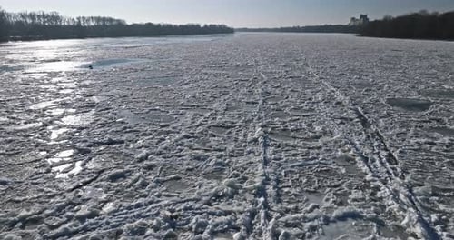 Bridge with traffic over a frozen river with ice floes.