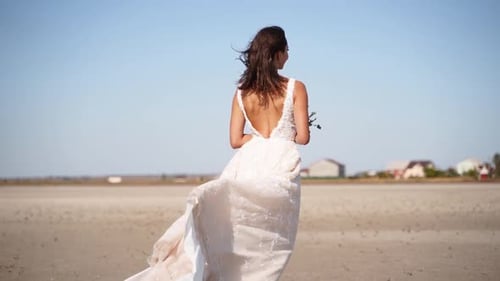 Happy Young Bride with Bouquet of Flowers Going at Desert Landscape Elegance Lady in Gorgeous