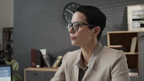 Mature Female Recruiter in Formalwear Conducting Job Interview at Office Desk