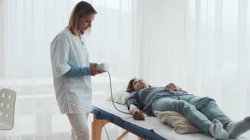Young female doctor checks senior woman's blood pressure in doctor's office
