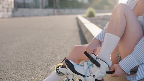 Woman Putting On Roller Blades Outside