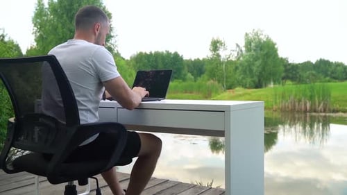 Close-up shot of a freelancer diligently working on a laptop in an outdoor setting