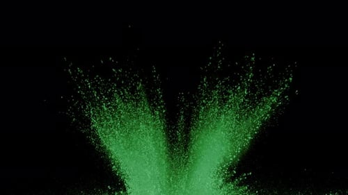 Green powder explosion bursts across a black backdrop in super slow motion
