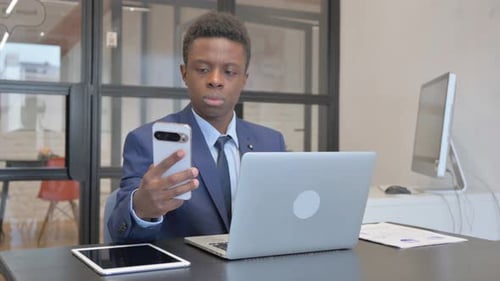 Young Adult in Suit Looking at Smartphone