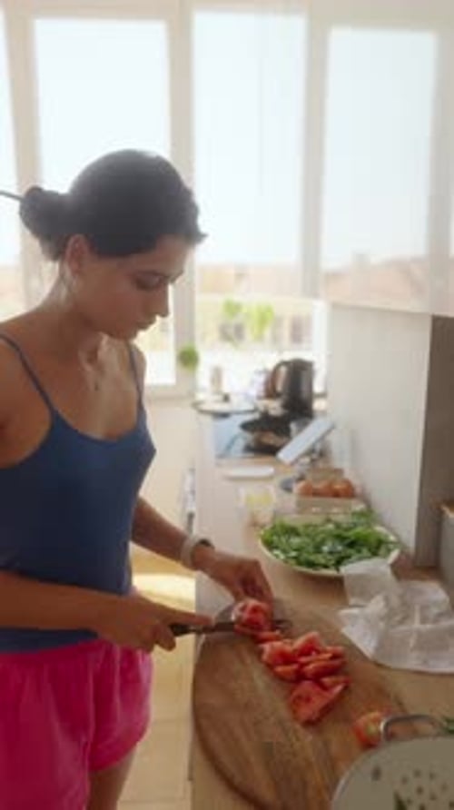 Woman Chopping Tomatoes in Sunny Kitchen