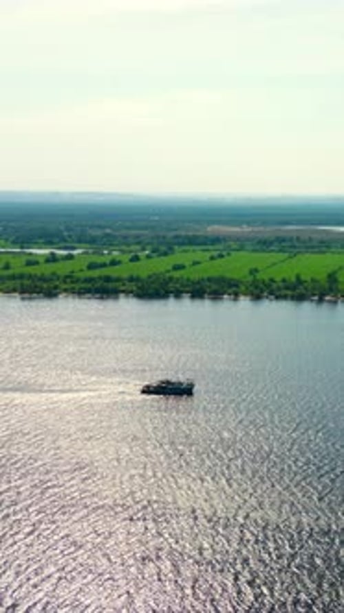 Cargo Ship Navigating on a Wide River on a Sunny Day Clip