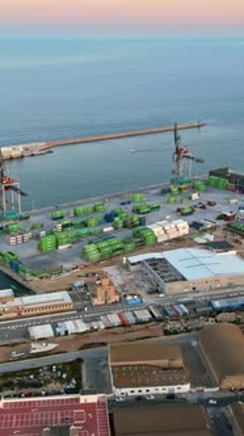 Aerial drone view of a Cargo terminal in Alicante, Spain at sunset. Vertical