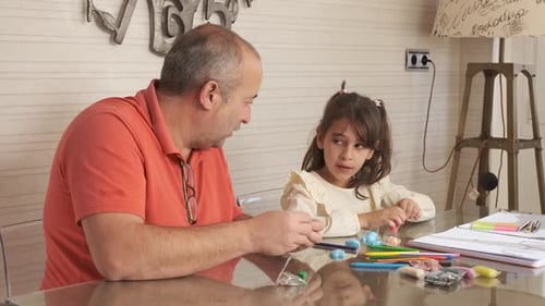 Father and Daughter Play with Modeling Clay at Home
