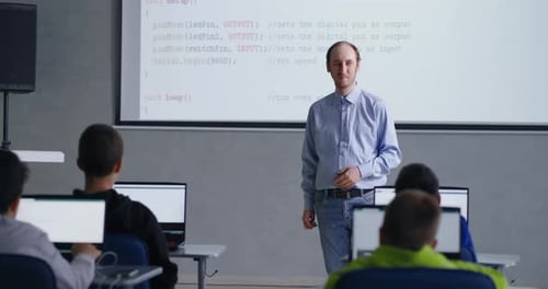 Teacher Explains Programming to Students in Classroom