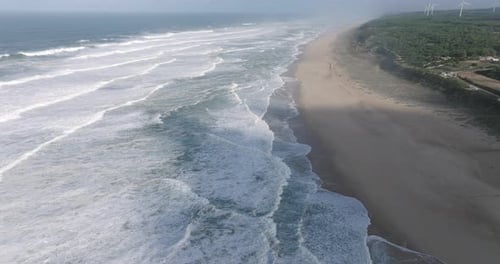 Aerial drone shot of waves coming into shore on a day with giant waves in Nazaré, Portugal, Europe.