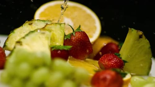 Refreshing Fruits with Water Drizzling in Close Up