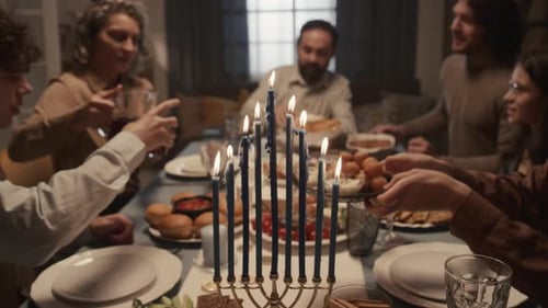 Family Dinner with Lit Hanukkah Menorah